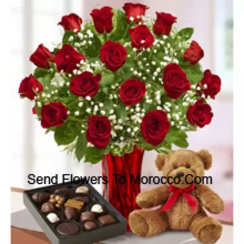 25 Rosas rojas con algunos helechos en un jarrón de vidrio, un lindo osito de peluche marrón y una caja de chocolates importados