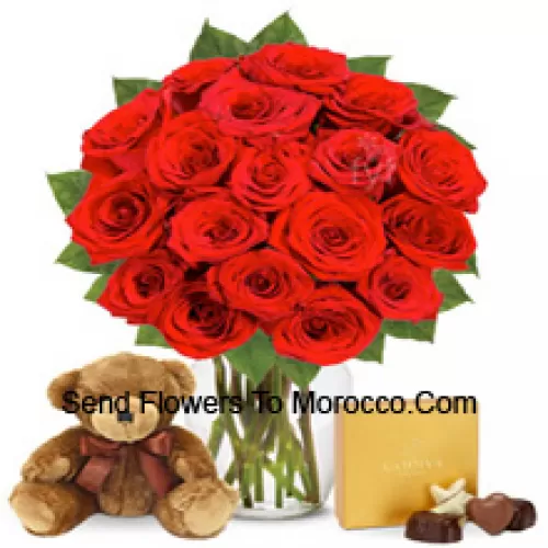 11 roses rouges avec quelques fougères dans un vase en verre accompagnées d'une boîte de chocolats importée et d'un mignon ours en peluche brun de 12 pouces de hauteur