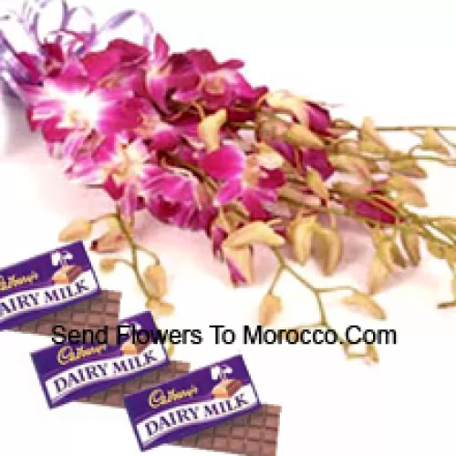 Un magnifique bouquet d'orchidées roses accompagné de chocolats assortis Cadbury