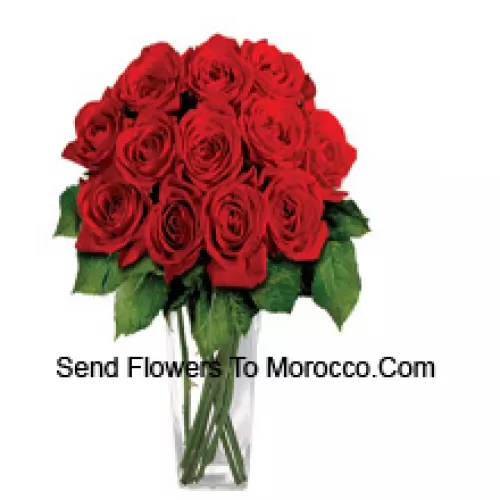 15 Red Roses With Some Ferns In A Glass Vase