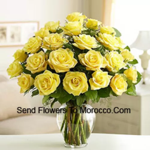 25 Yellow Roses With Some Ferns In A Glass Vase