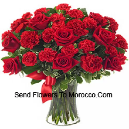 15 Red Roses And 10 Red Carnations With Some Ferns In A Glass Vase