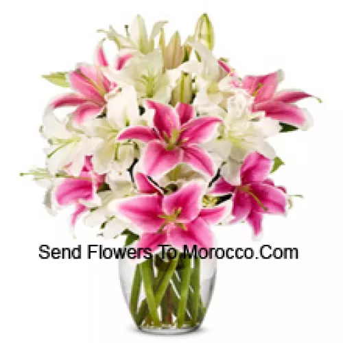 White And Pink Lilies With Some Ferns In A Glass Vase