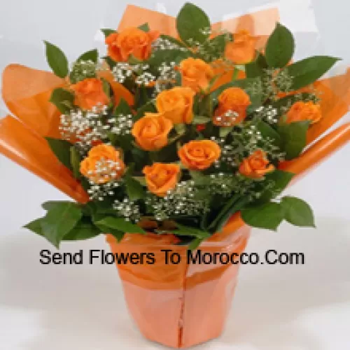 Un bel arrangement de 19 roses orange avec des remplissages saisonniers