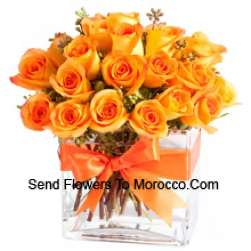 25 Orange Roses With Some Ferns In A Glass Vase