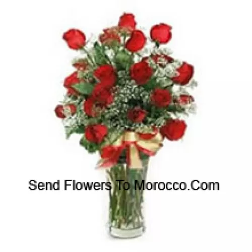 25 Red Roses With Some Ferns In A Glass Vase