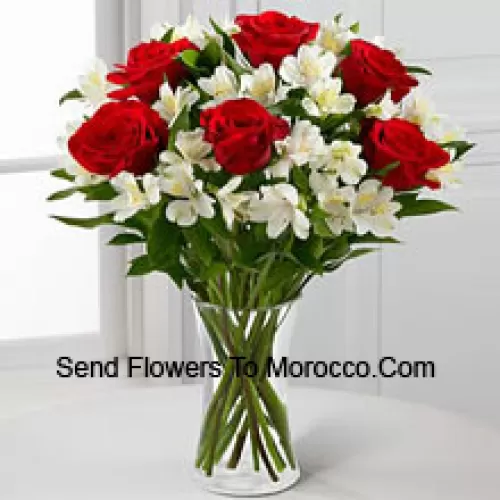 7 Roses rouges avec des fleurs blanches assorties et des remplisseurs dans un vase en verre