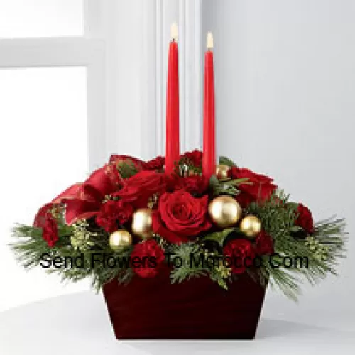 An exquisite display of holiday beauty to add warmth and cheer to their special celebrations. Rich red roses and burgundy mini carnations are set to impress surrounded by lush holiday greens, seeded eucalyptus, gold glass balls and a gold-edged red ribbon arranged elegantly around two red taper candles. Presented in a chocolate brown bamboo container, this centerpiece will usher in joy and goodwill with each treasured bloom (Please Note That We Reserve The Right To Substitute Any Product With A Suitable Product Of Equal Value In Case Of Non-Availability Of A Certain Product)